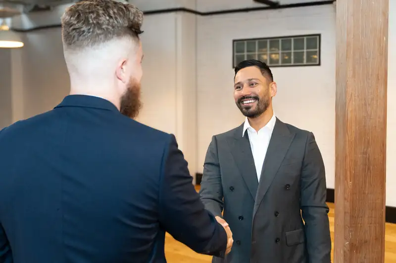 Tank Insurance broker greeting a client with a handshake in the office