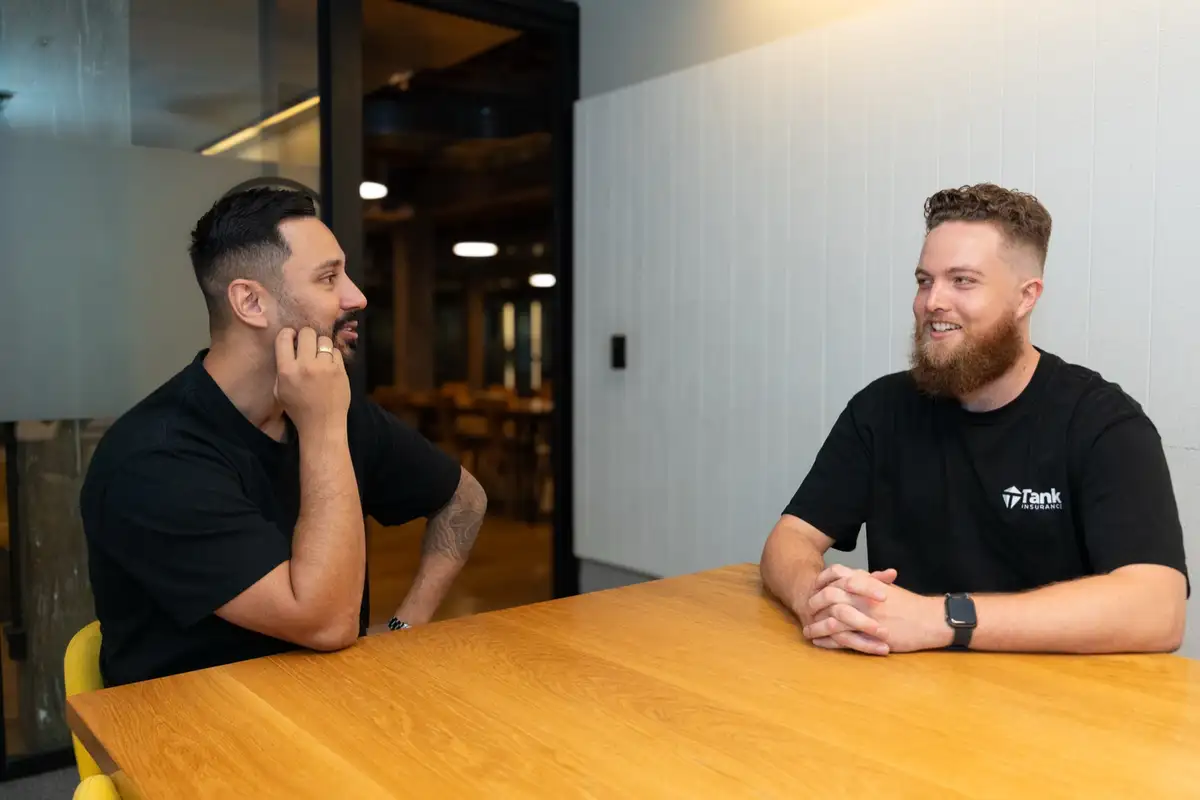 Tank Insurance team members having a candid conversation in the office