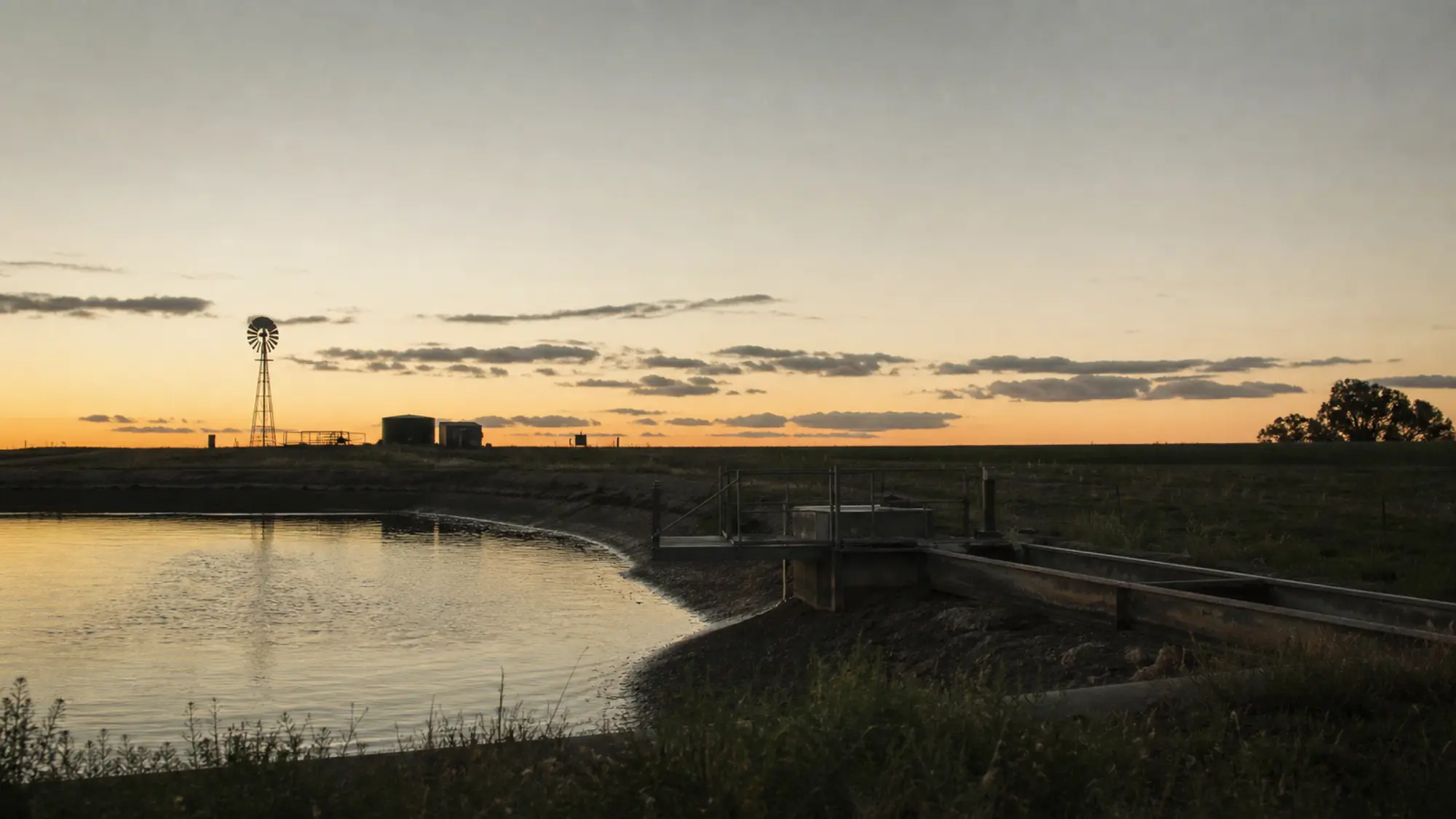 Farm water infrastructure at dusk - water management design behind agricultural engineers insurance