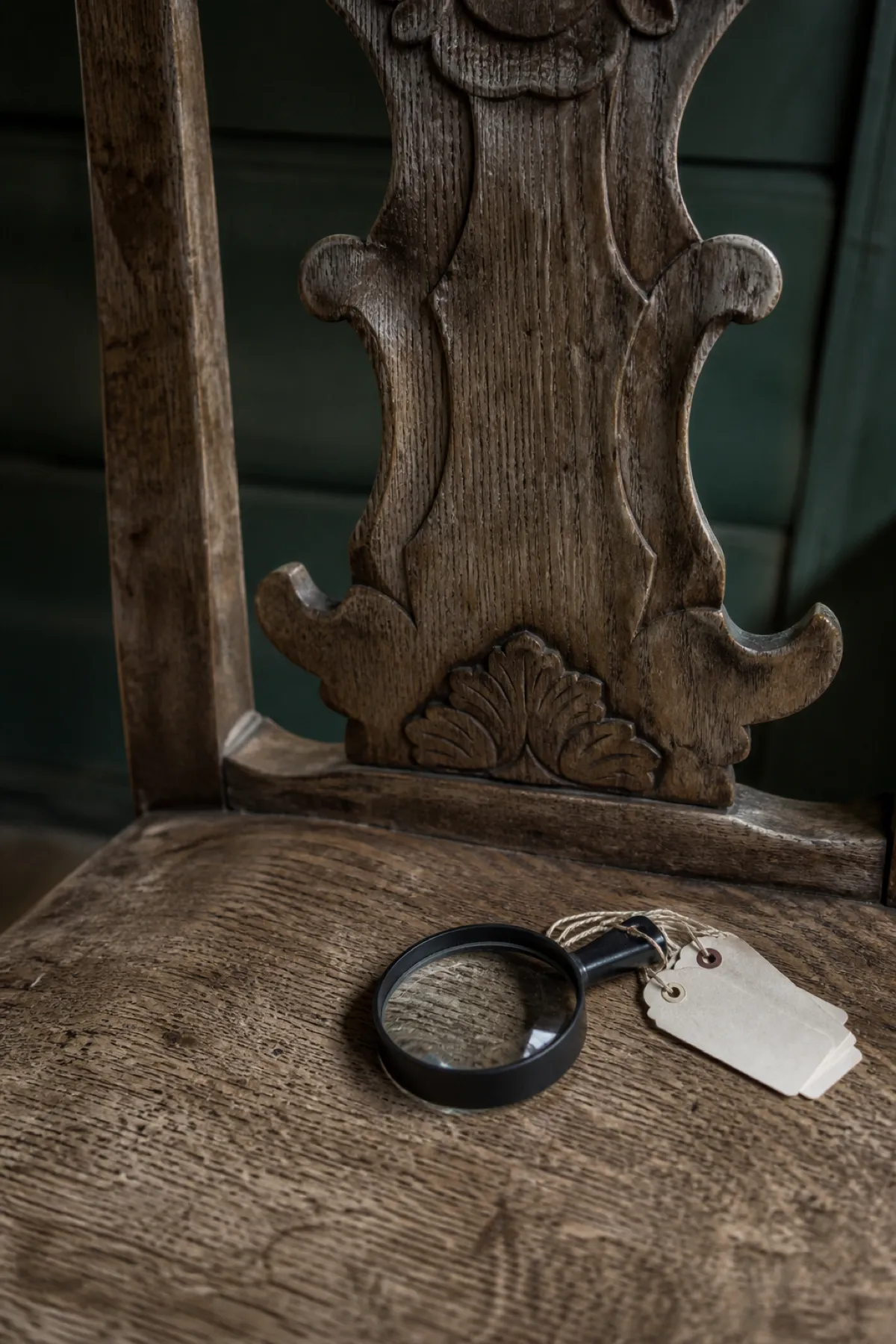 Carved oak chair with loupe and tags, professional indemnity cover for antiques dealers