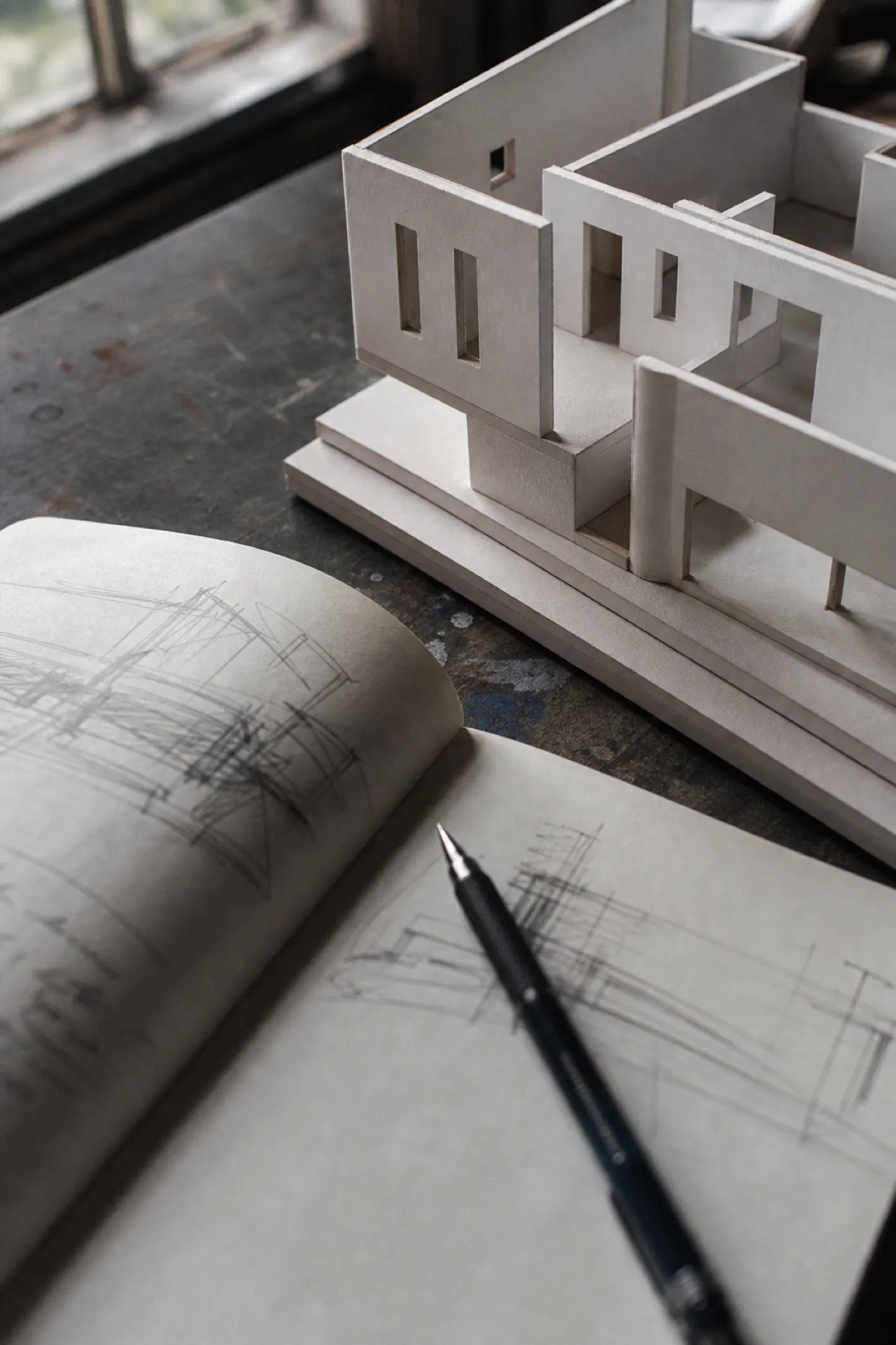 Card study model and sketchbook on a studio desk, professional indemnity cover for architects