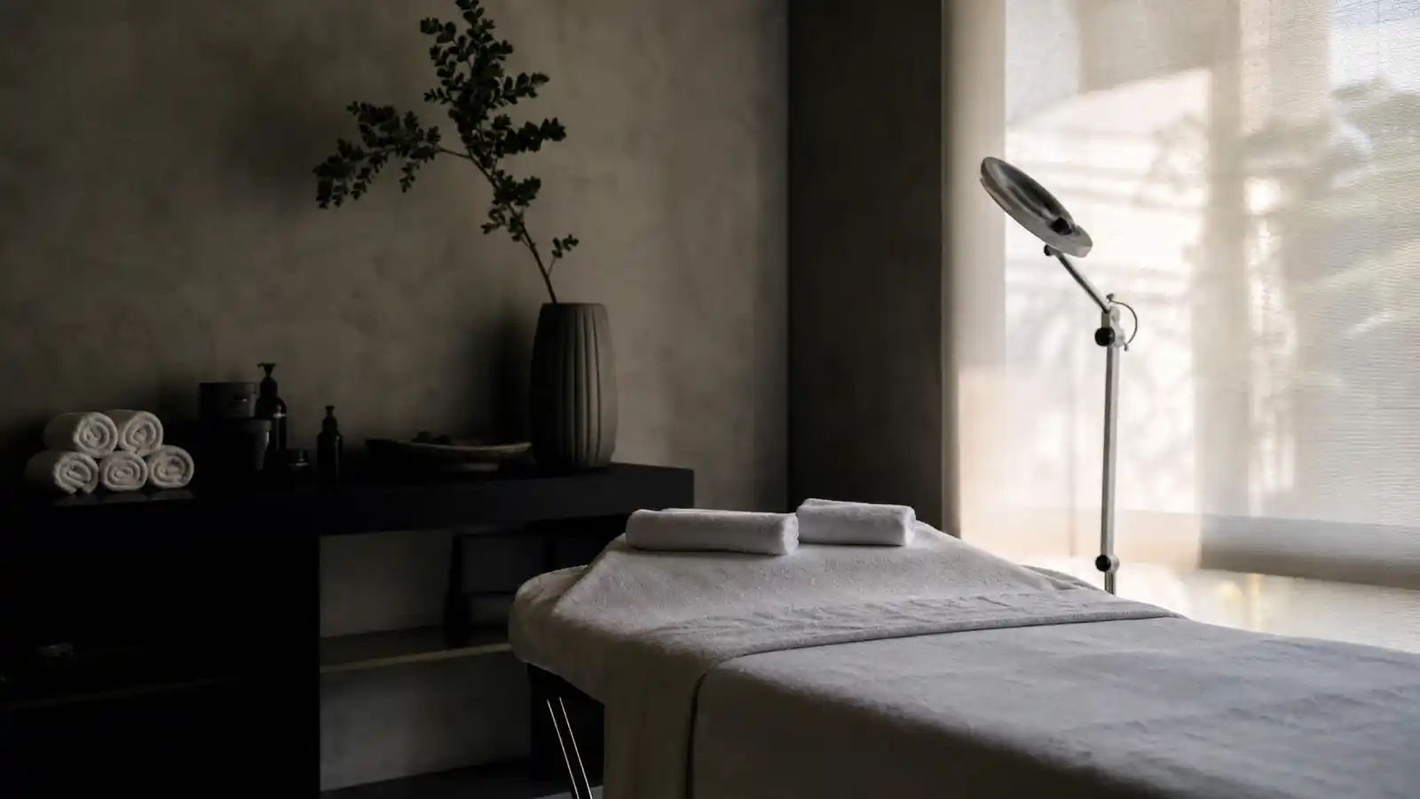 Empty beauty treatment room with towelled bed and facial lamp, beauty therapist professional indemnity insurance