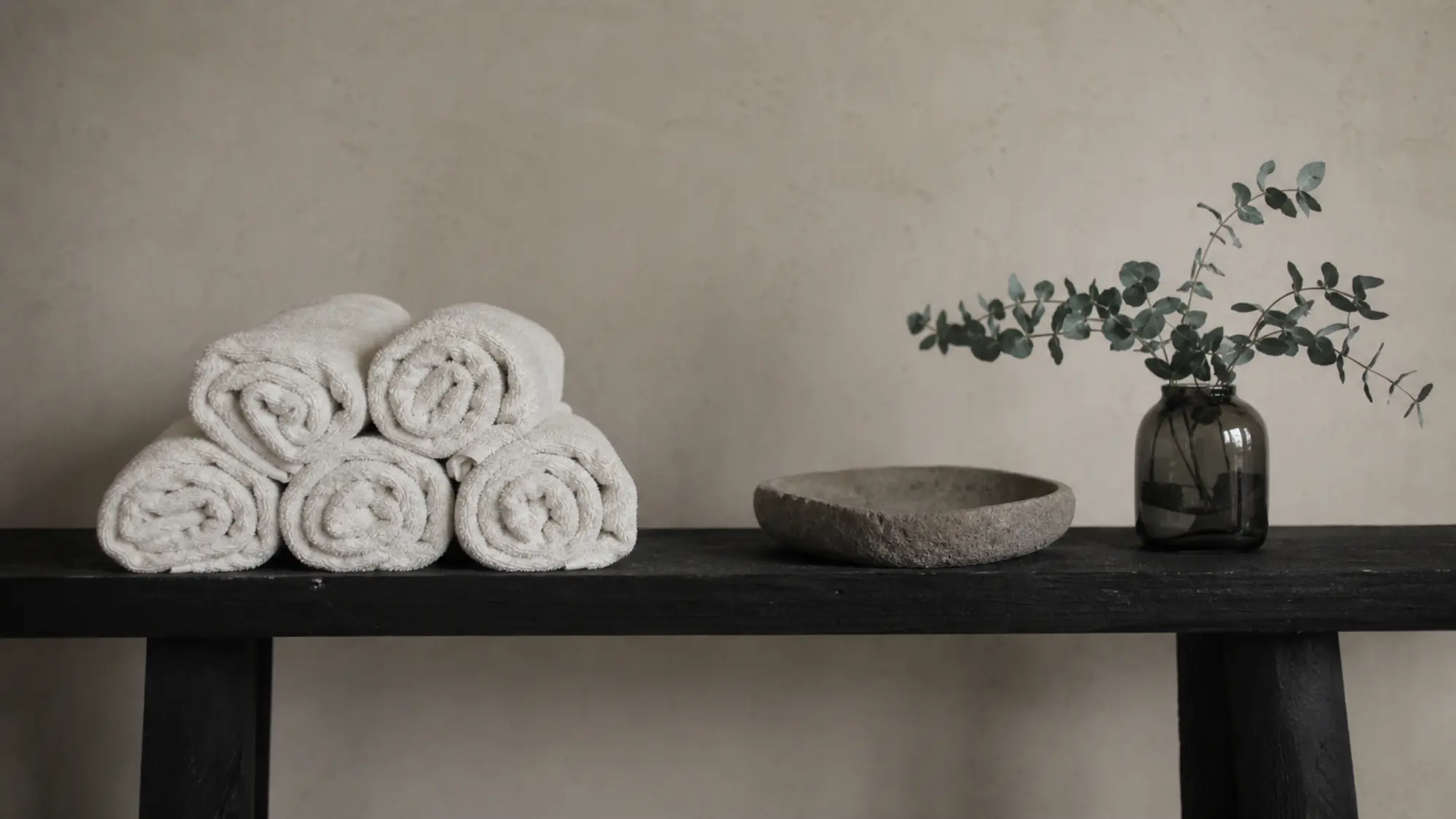 Salon bench with towels and eucalyptus stems, beauty therapist professional indemnity insurance quote