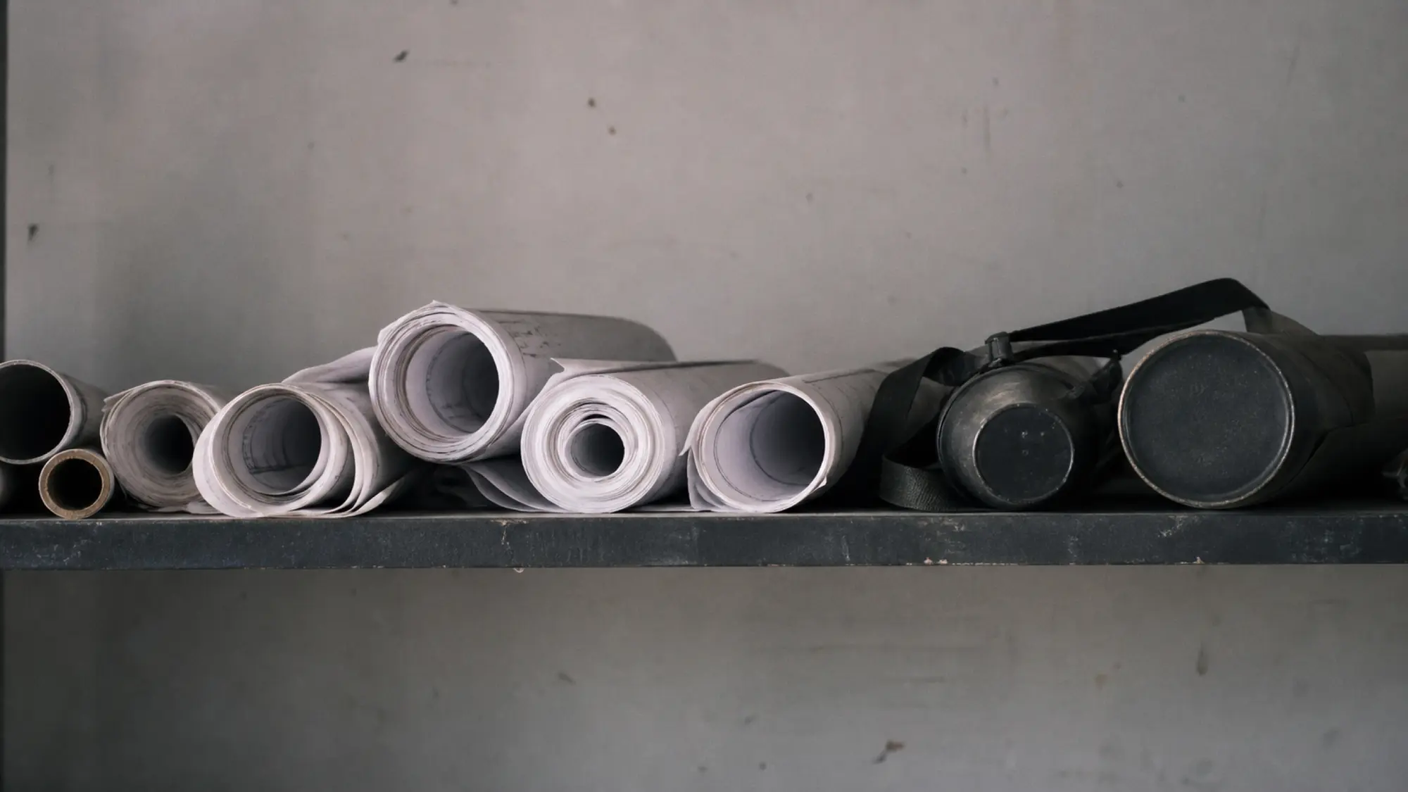 Rolled drawing sets on a site office shelf, BIM manager professional indemnity insurance quote