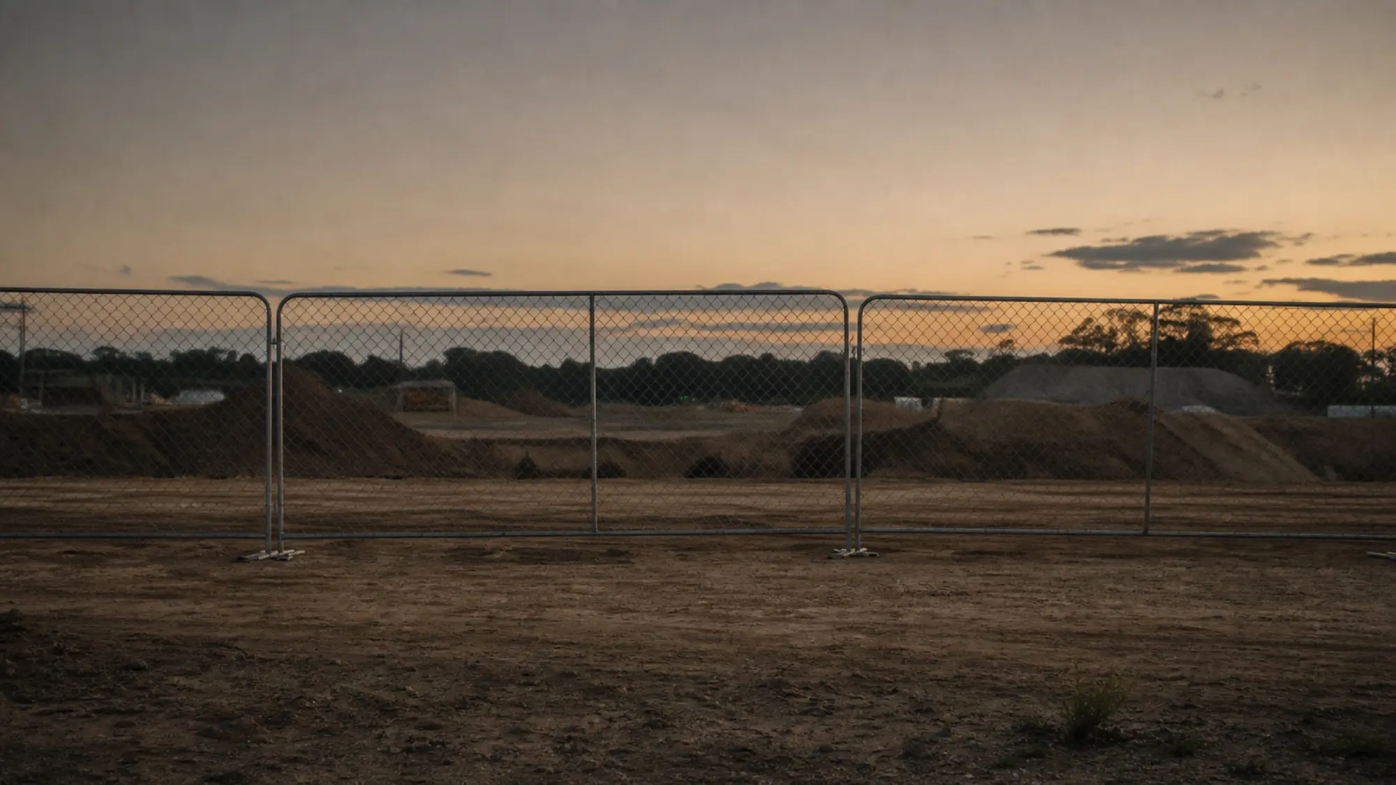 Temporary fencing securing a construction site at dusk - contract works insurance claims support