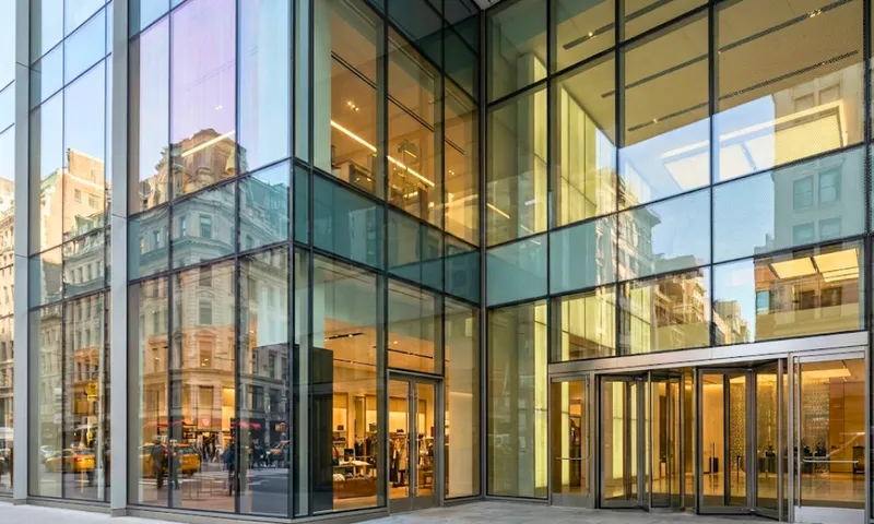 Upscale retail boutique with full-height external glass shopfront windows at dusk