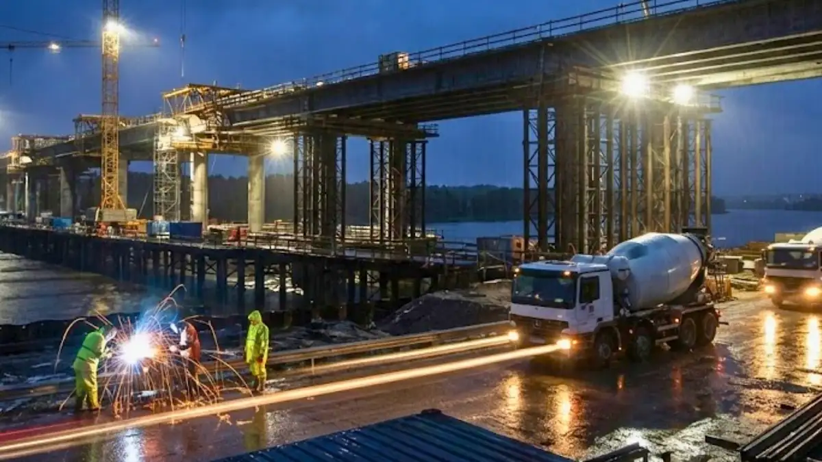 Night-time civil construction site with welding sparks and cement truck building bridge infrastructure - 24/7 contract works insurance protection