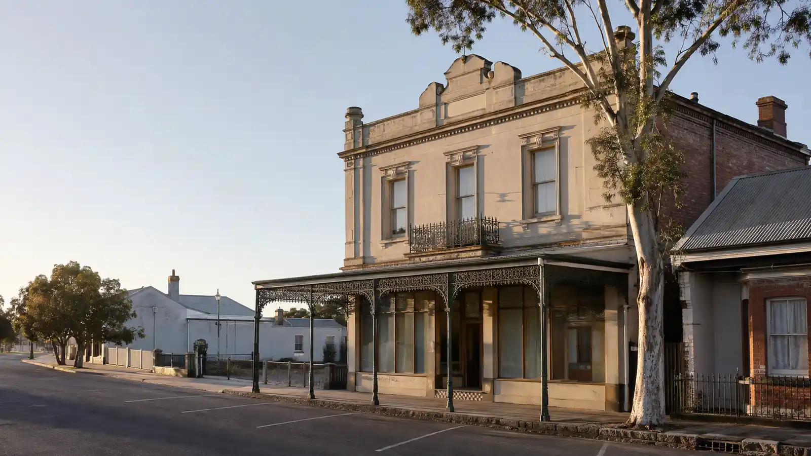 Victorian rendered shop-top building with a cast-iron verandah and upstairs residence on a regional main street
