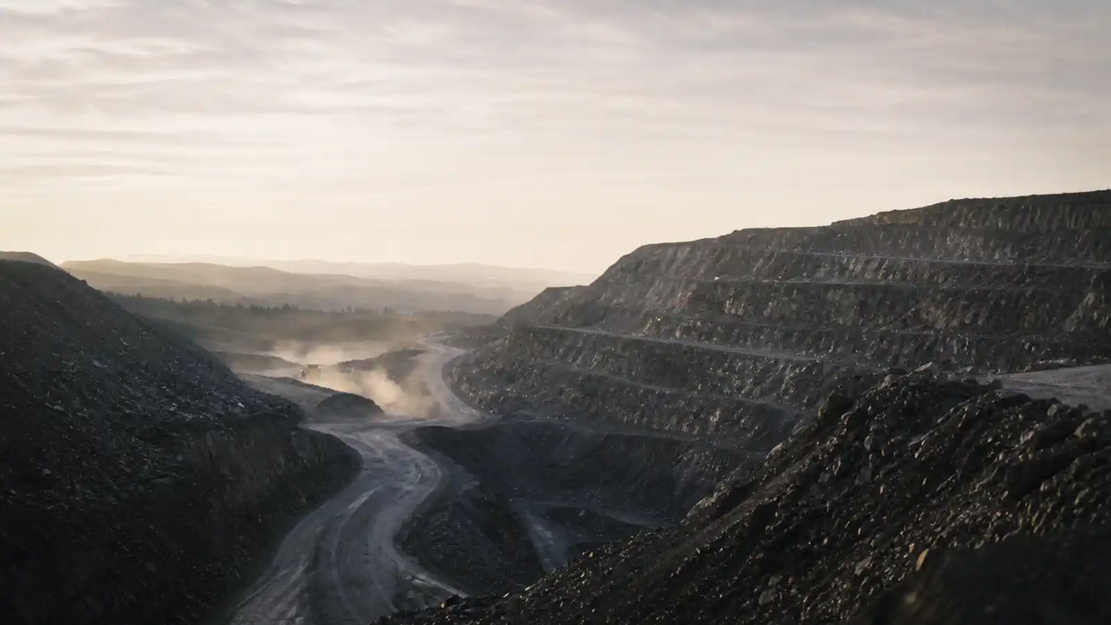 Open-cut mine pit with haul roads and benched walls
