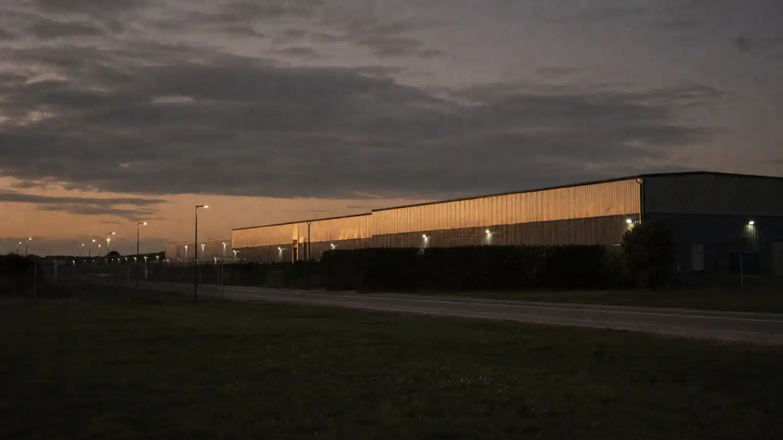 Logistics estate at dusk with trucks at loading docks, freight forwarder professional indemnity insurance