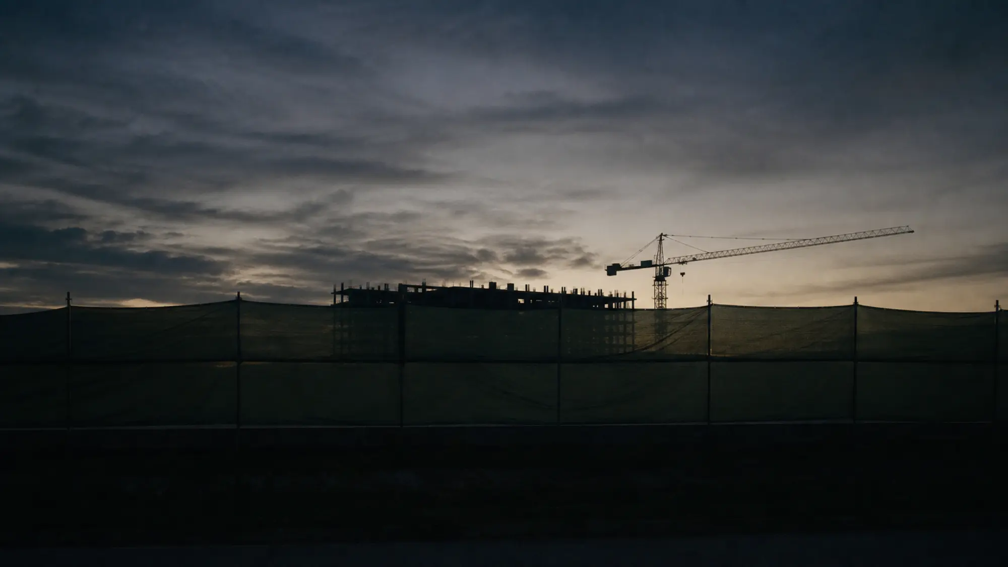 Construction site fencing and cranes at dusk for labour hire injury liability