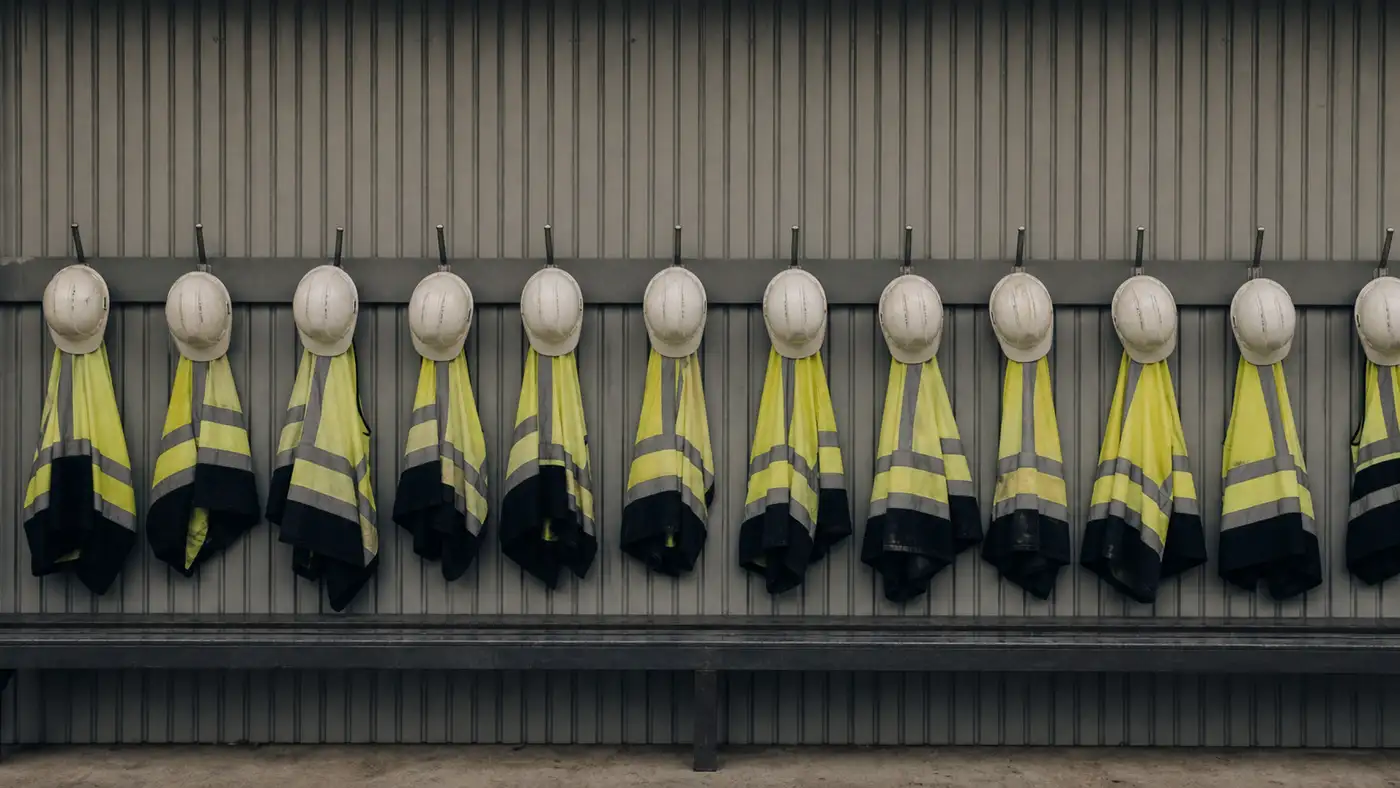 Row of high-visibility vests and hard hats for a labour hire insurance program