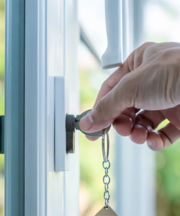 Landlord and insurance broker finalising rental property insurance policy with handshake over documents and property keys