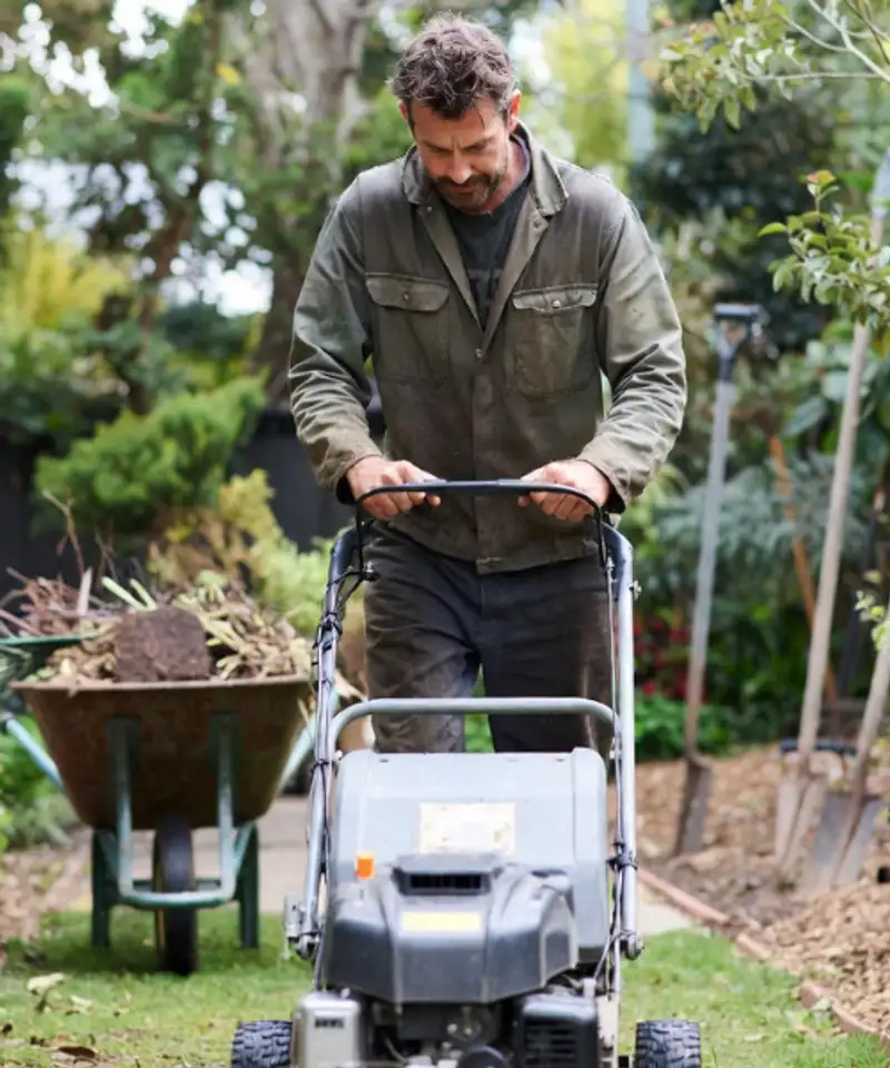 Professional landscaper operating commercial lawn mower in residential garden – public liability insurance for landscaping businesses Australia