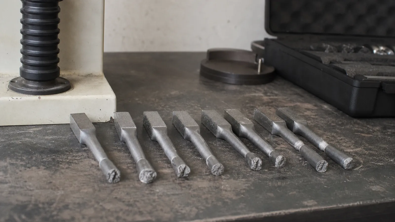 Fractured tensile test specimens on a bench - materials failure analysis risk