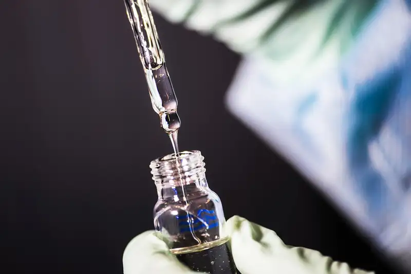 A gloved hand using a pipette to fill a glass vial in a clinical research laboratory.