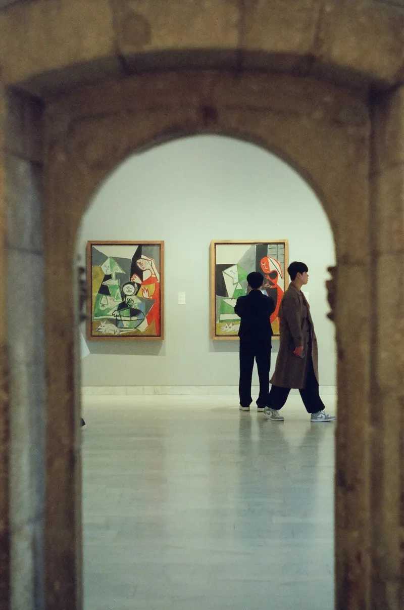 People observing paintings in an art gallery