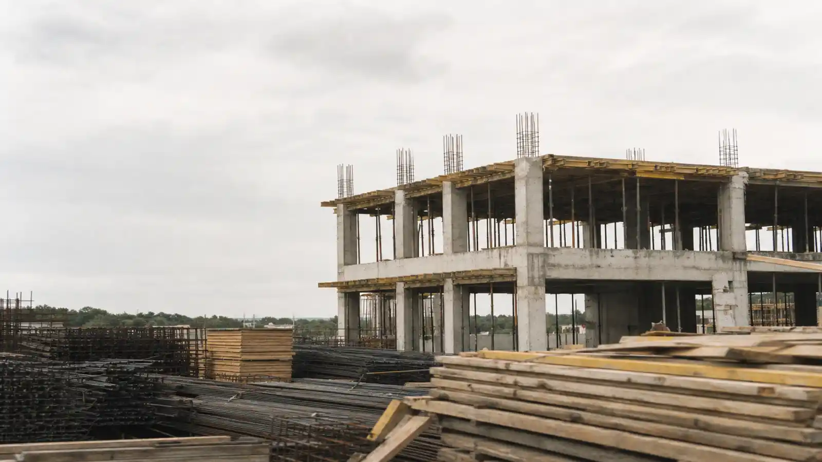 Concrete frame and stacked materials on site, the cost-planning work quantity surveyor PI insurance covers