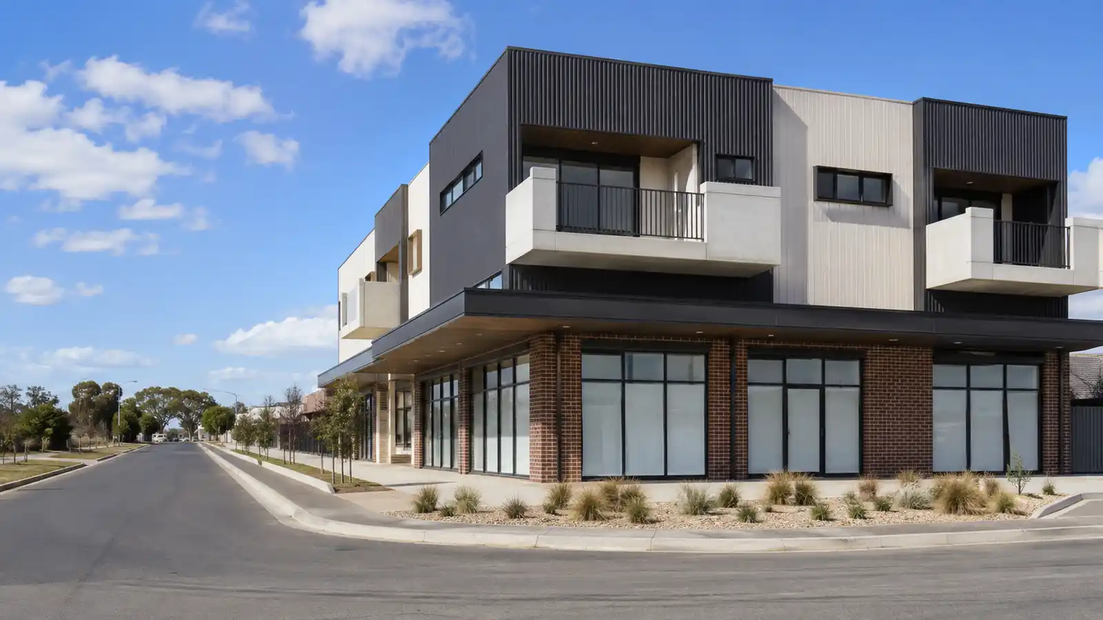 Modern corner mixed-use building with two glazed retail tenancies and apartments above