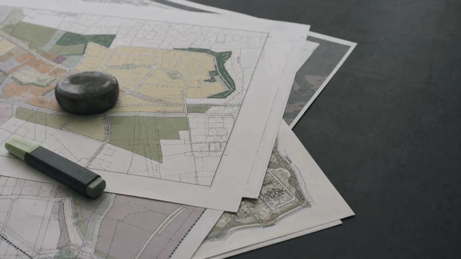 Zoning maps and overlay plans on a desk, planning advice behind town planner PI claims